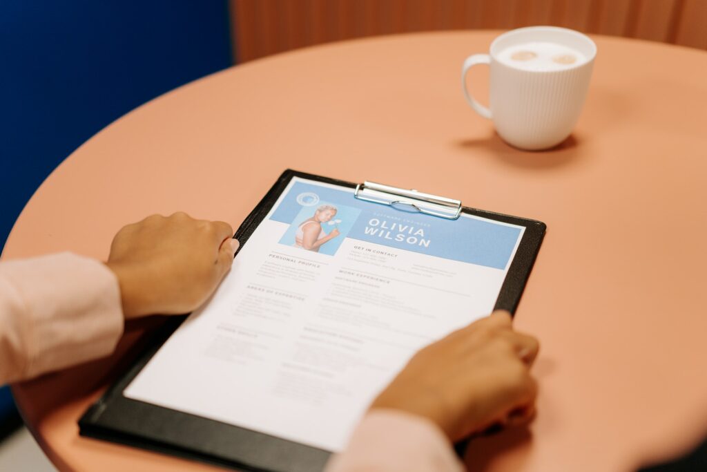 Woman holding someone's resume while reading it.