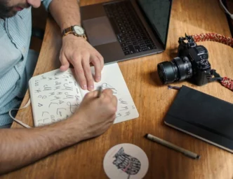 Man with a laptop and camera taking notes