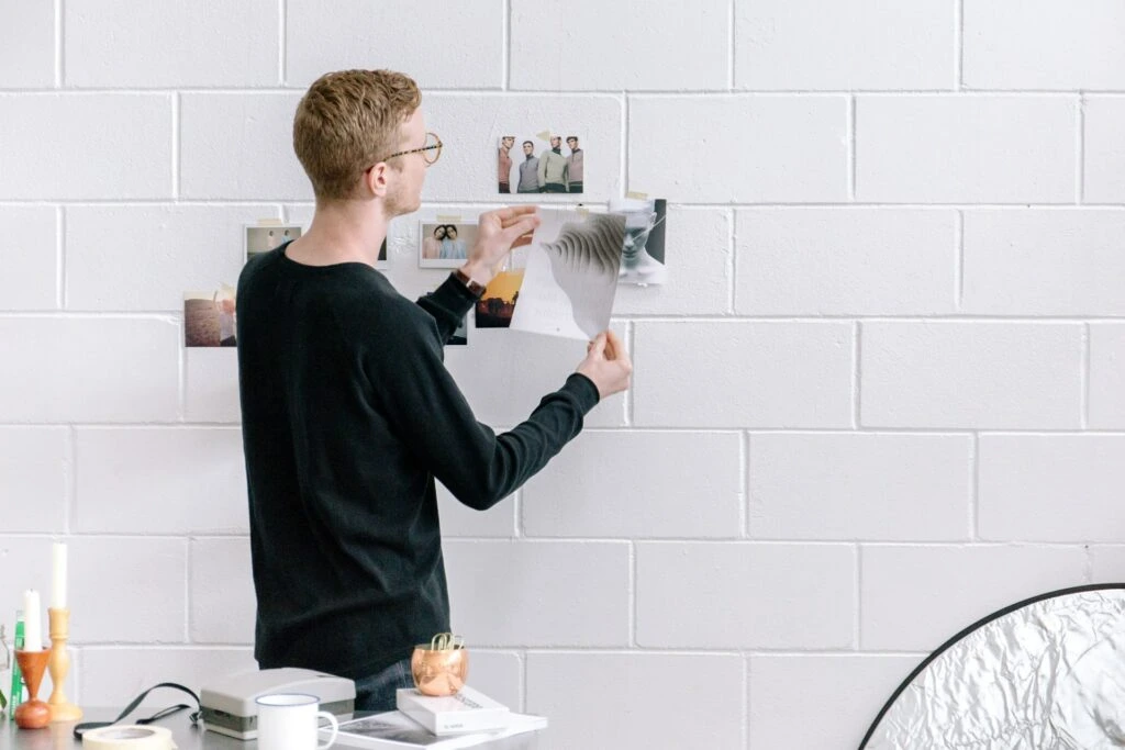 Man looking at photos on a wall