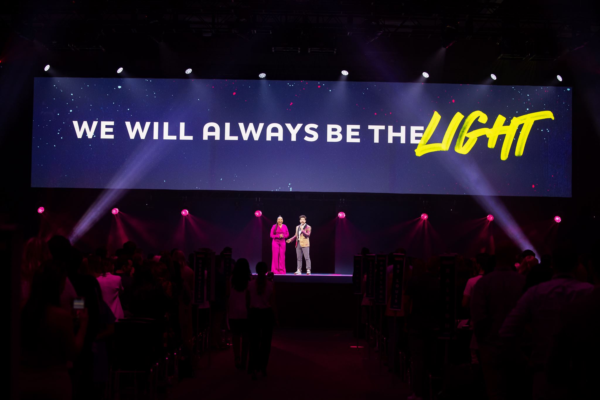 Korryn Williamson and Matt Gonsalves on stage at "Without Limits" conference. Sign behind them reads: "We Will Always Be The Light"