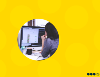 Circle crop image of a woman working alone at her desk. Yellow graphic background.