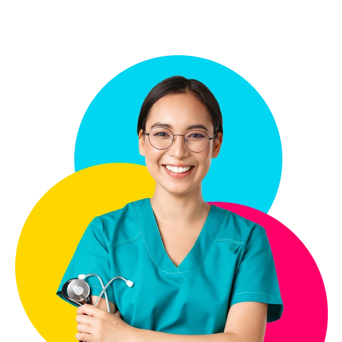 A young woman employed by a healthcare staffing agency that's wearing glasses and green scrubs and holding a stethoscope.