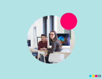 Light blue background with magenta accent circle. Circle crop photo of a man and a woman sitting at adjacent desks with computers.