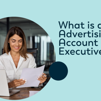 Woman with brown hair sitting at a desk in an office reviewing papers and What is An Advertising Account Executive?