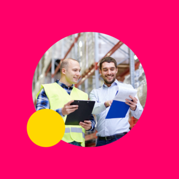 Two warehouse workers talking and looking at their clipboards